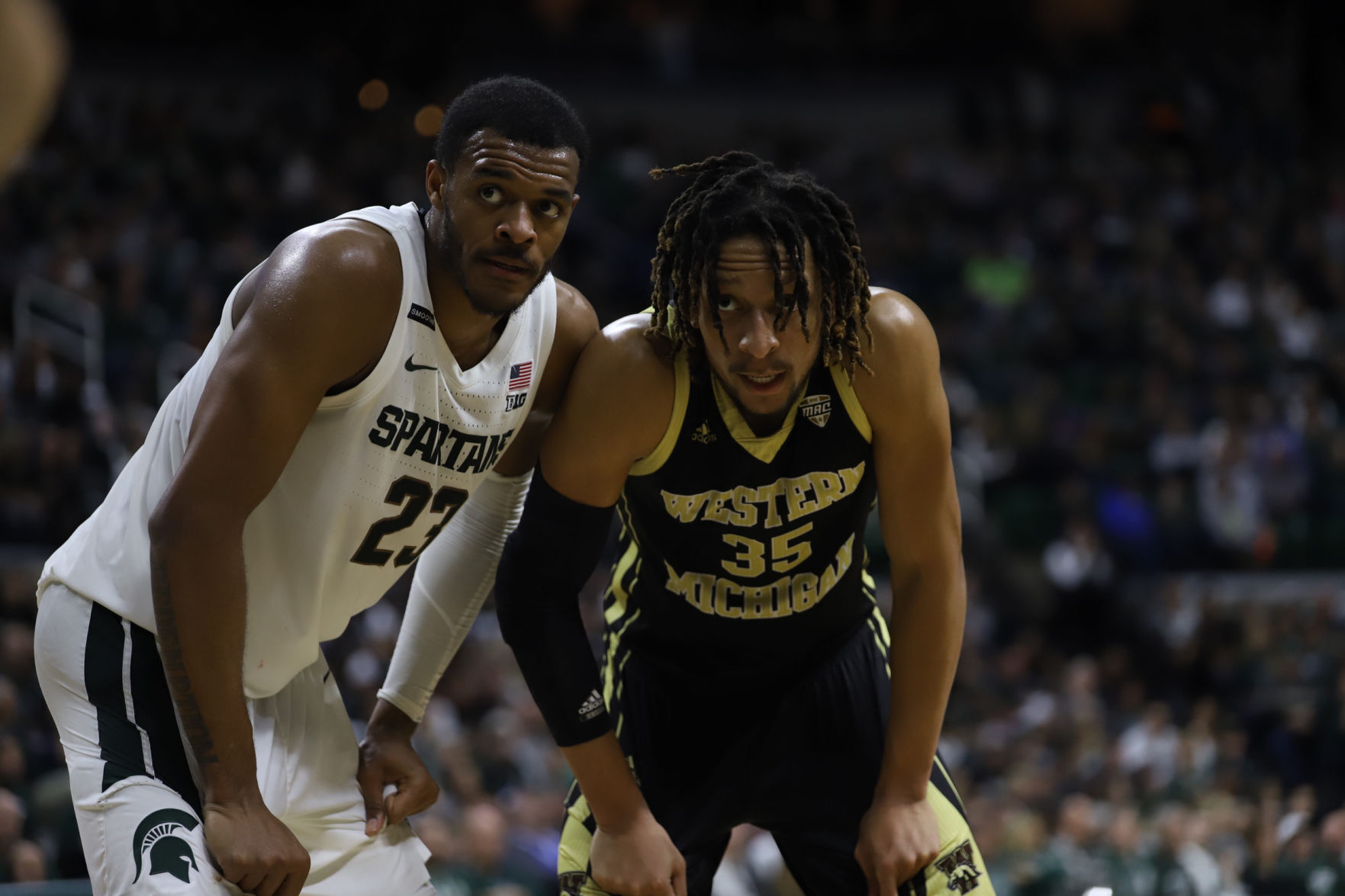 Michigan State's Xavier Tillman (23) and Western Michigan's Brandon Johnson (35) wait for the resume in action.